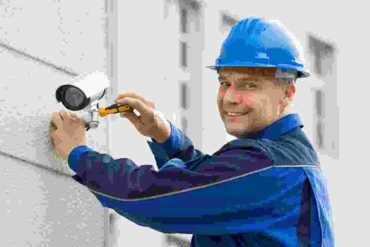 A man in blue jacket holding up a camera.