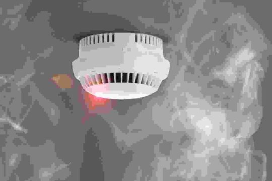 A smoke detector is shown with red light.
