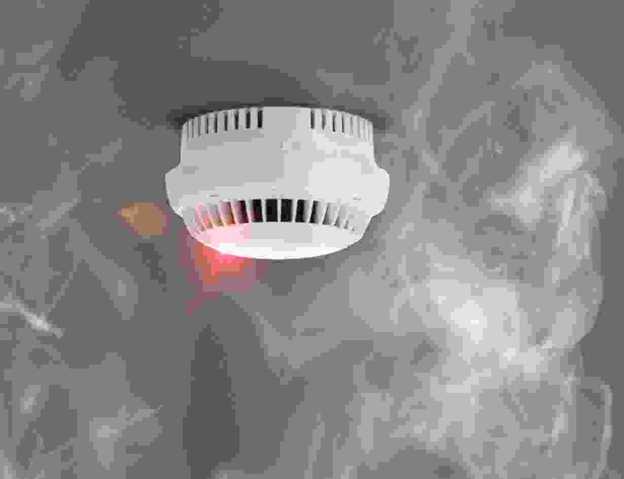A smoke detector is shown with red light.