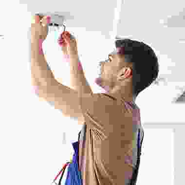 A man holding scissors in his hand while standing up.