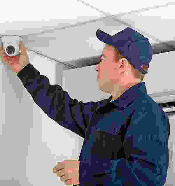 A man in blue shirt holding up camera.