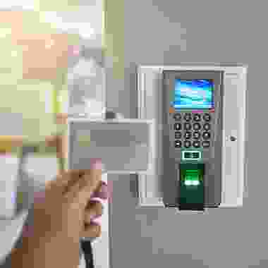 A person is holding their id card in front of the electronic device.