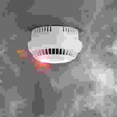 A smoke detector is shown with the light on.