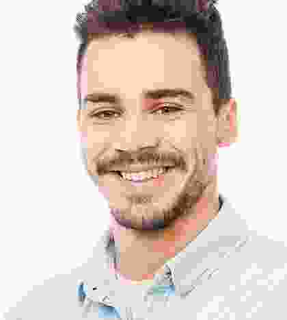 A man with beard and mustache smiling for the camera.