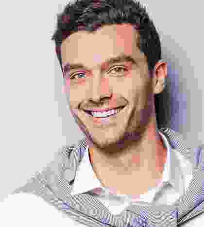 A man with a beard and smiling for the camera.