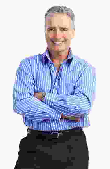 A man in blue shirt and black pants with arms crossed.