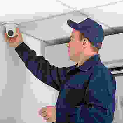 A man in blue shirt holding up a camera.