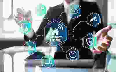 A man is sitting at his desk with smart home icons.