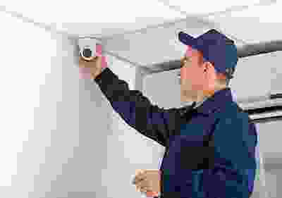 A man in blue shirt holding up a camera.