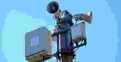 A person standing on top of a pole.