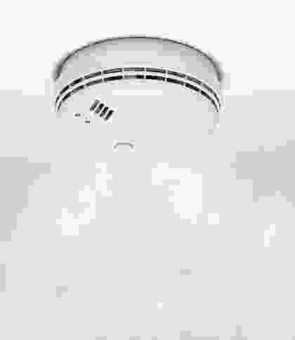 A white smoke detector is shown in the sky.