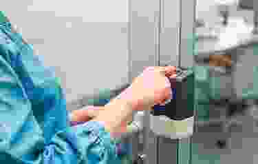 A person is holding a bottle of liquid.