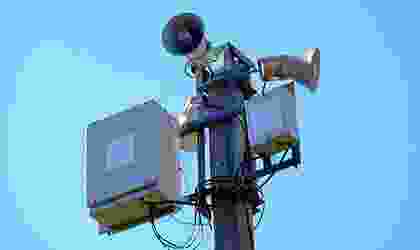 A person on top of a pole with a camera.