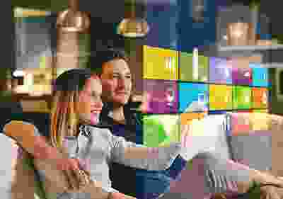 Two people sitting in a room with a colorful background