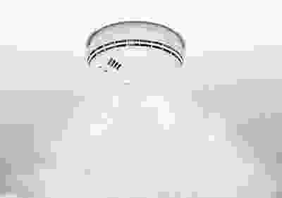 A white ceiling with a round shaped object in the middle of it.