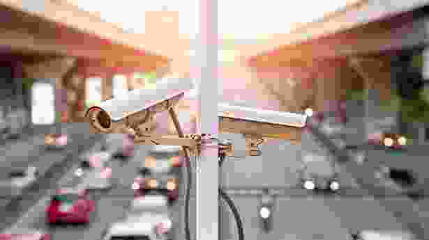 A couple of cameras on top of a pole.