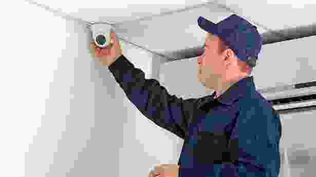 A man in blue shirt holding up a camera.