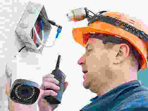 A man holding two walkie talkies in his hand.