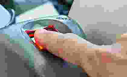 A person is using the parking meter to pay.