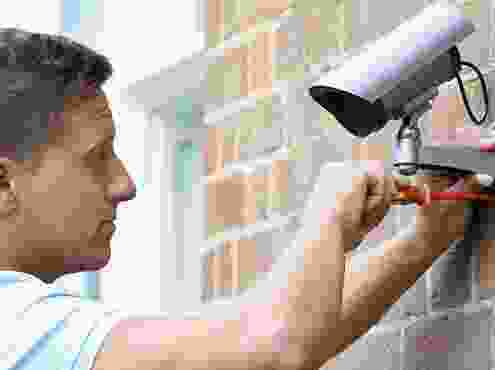 A man holding onto the camera and looking at it