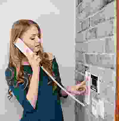 A woman holding on to the phone while looking at it.