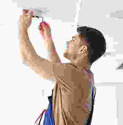 A man holding scissors up to the ceiling.