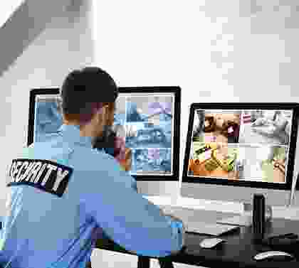 A security guard is sitting at his desk