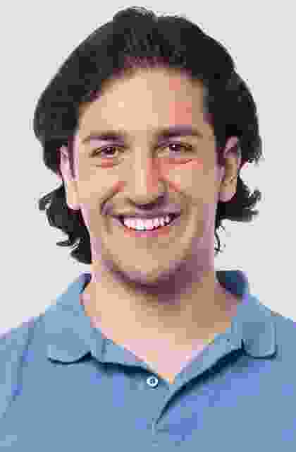 A man with long hair and a blue shirt.