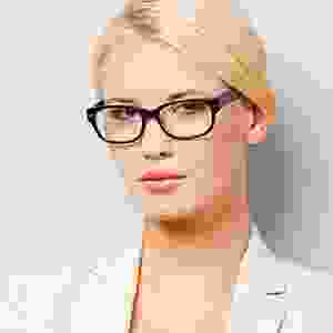 A woman with glasses is wearing a white jacket.