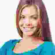 A woman with long hair is smiling for the camera.