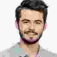 A man with a beard and mustache smiling for the camera.