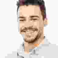 A man with a beard and mustache smiling for the camera.