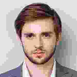 A man with short hair and beard wearing a suit.