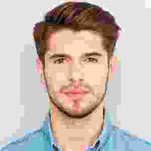 A man with short hair and beard wearing blue shirt.