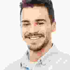 A man with a beard and mustache smiling for the camera.