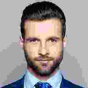 A man with a beard and suit on.