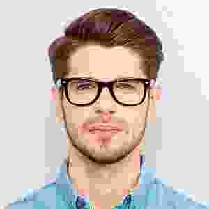 A man with glasses is smiling for the camera.